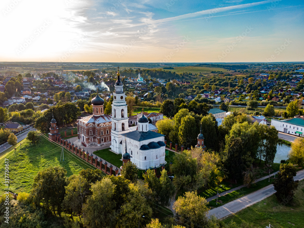 Aerial photo of old russian Volokolamsk Kremlin at golden hour in summer, beautiful Russian nature in the background