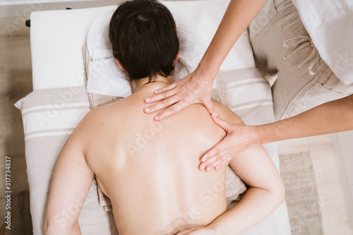 young caucasian Woman receiving back massage from physiotherapist female in clinic. Physiotherapy concept