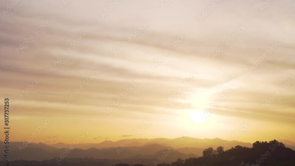 Sunset among the peaks of the mountains and wooded hills. Cirrus golden and orange clouds. Colorful beautiful landscape Sunset among the peaks of the mountains and wooded hills. Cirrus golden and orange clouds. Colorful beautiful landscape