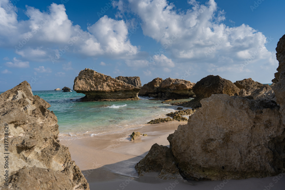 beautiful view on the lonely Fazayah Beach, Salalah Oman, Fantastic seascape, great outdoor scene of Beauty of nature concept background, blue sea, few clouds, light sandy beach, rocks in the water beautiful view on the lonely Fazayah Beach, Salalah Oman, Fantastic seascape, great outdoor scene of Beauty of nature concept background, blue sea, few clouds, light sandy beach, rocks in the water