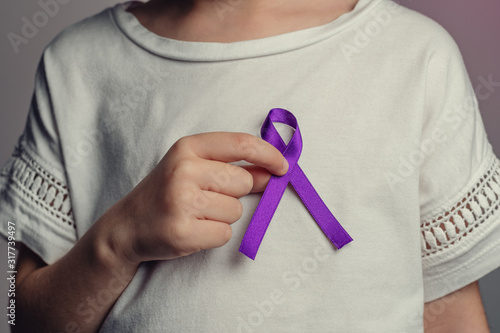 World cancer day. Small hands holding ribbon symbol. Cancer awareness month. Breast cancer.