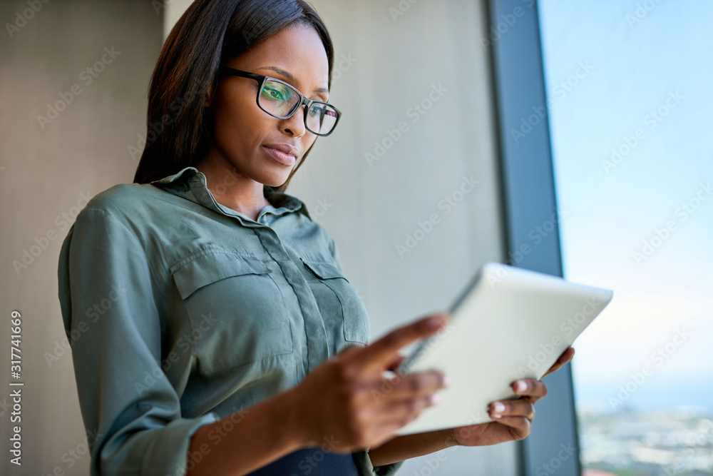 Confident young executive staying digitally connected in a modern office Confident young executive staying digitally connected in a modern office