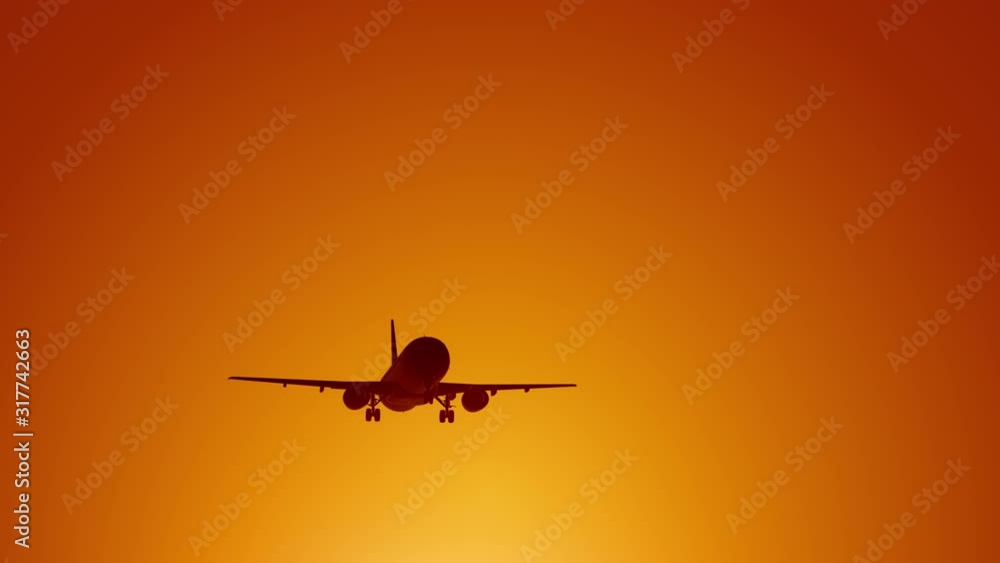 A large passenger plane takes off against the background of a sunset. Orange backgrand..Super slow motion.