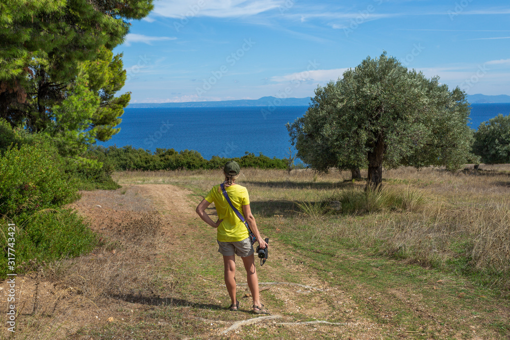 Woman walking with photo camera in beautiful greek landscapes. Horizontal color photography. Woman walking with photo camera in beautiful greek landscapes. Horizontal color photography.