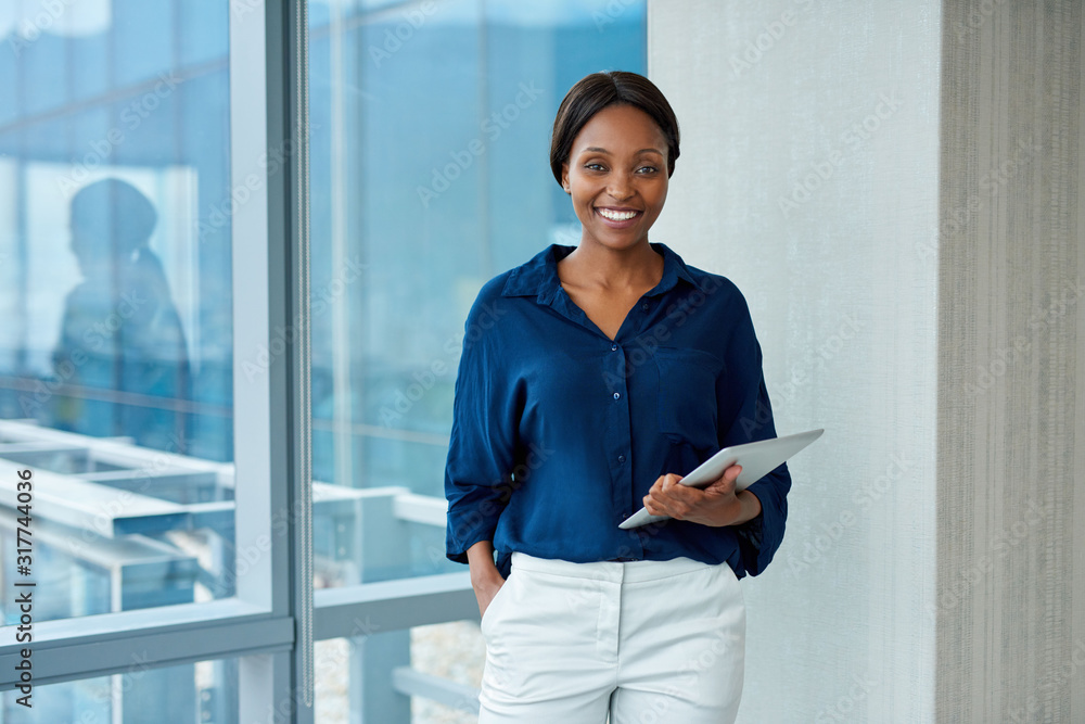 Smiling young businesswoman using technology for better business Smiling young businesswoman using technology for better business