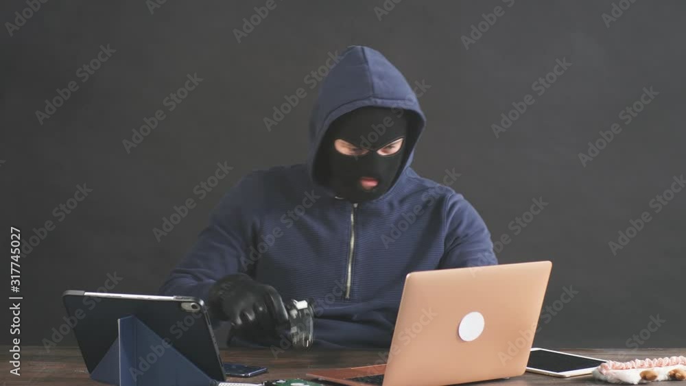 Hacker committing a crime with the aid of computers and information technology infrastructure, use gadgets for better hack. Cyberattack concept Hacker committing a crime with the aid of computers and information technology infrastructure, use gadgets for better hack. Cyberattack concept