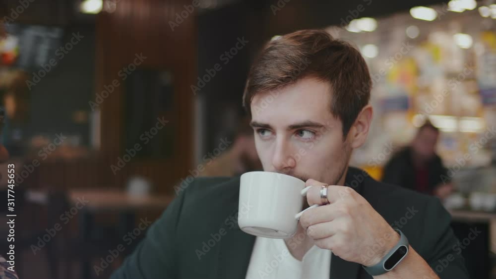 Close up of cute multiracial couple sitting in a cafe and drinking coffee.