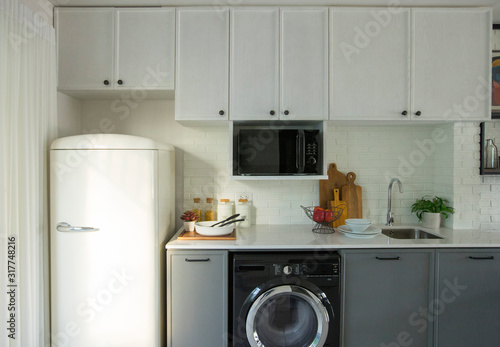 Modern white kitchen, gas stove with electric oven, fridge, clean design
