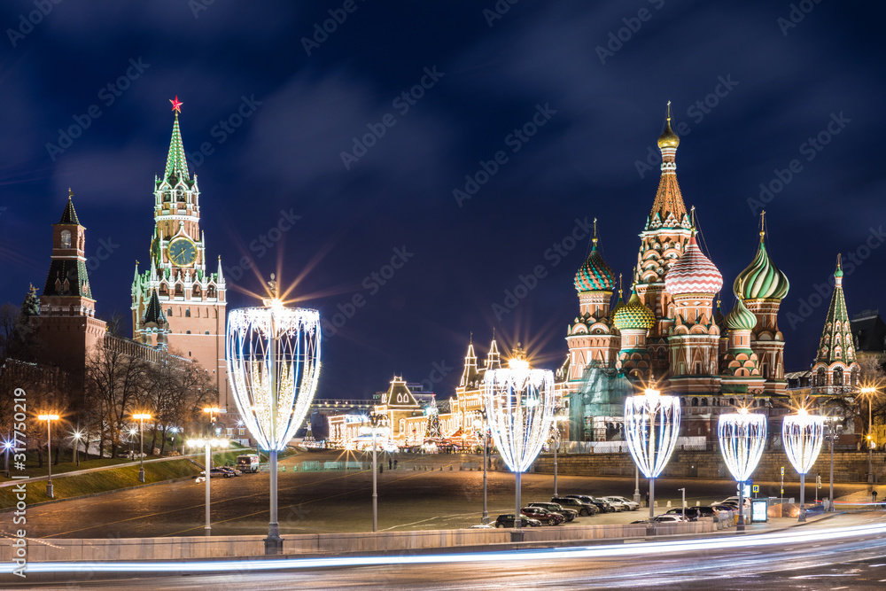 View on the illuminated Cathedral of Vasily the Blessed and towers of Moscow Kremlin on the Red square in Moscow, Russia in the cloudy night from the illuminated Bolshoy Moskvoretsky Bridge 