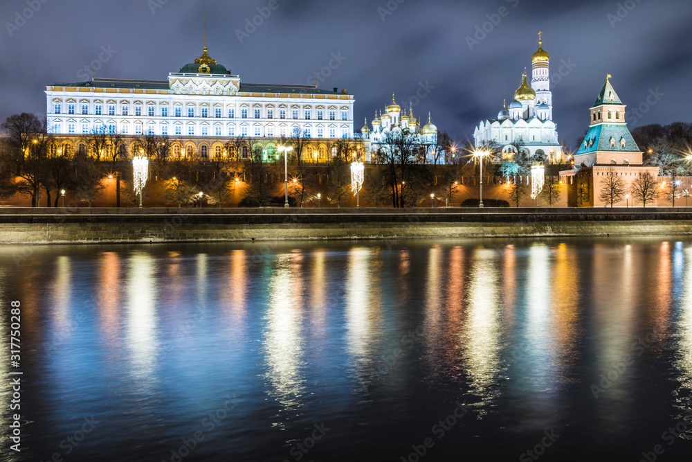 Illuminated Moscow Kremlin with Grand Kremlin Palace the government residence of president of Russia. View from the embankment of Moskva river. Evening urban landscape in the blue hour