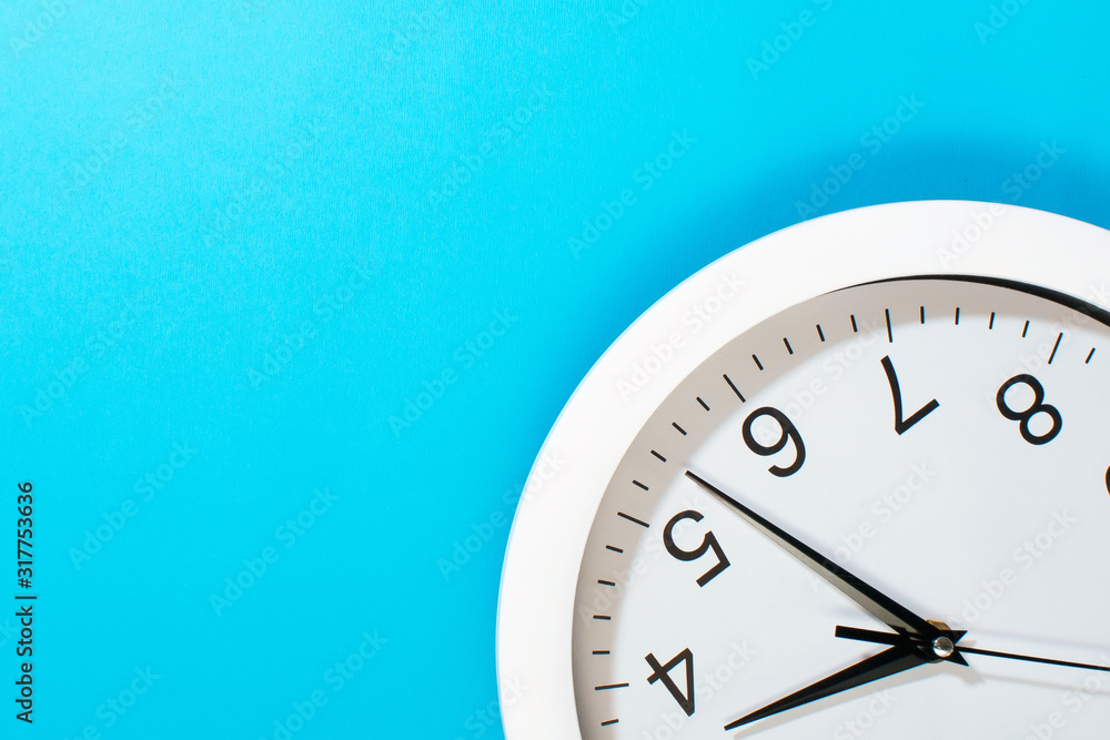 white clock on a blue background close-up. free space for text, copy space white clock on a blue background close-up. free space for text, copy space