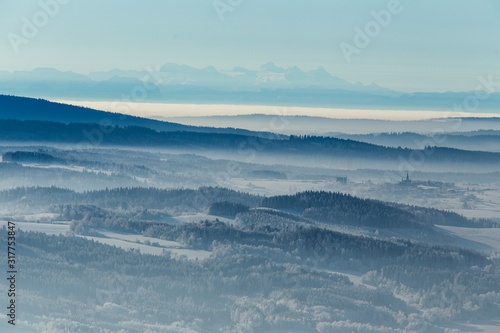 snow covered winter landscape with alps in background