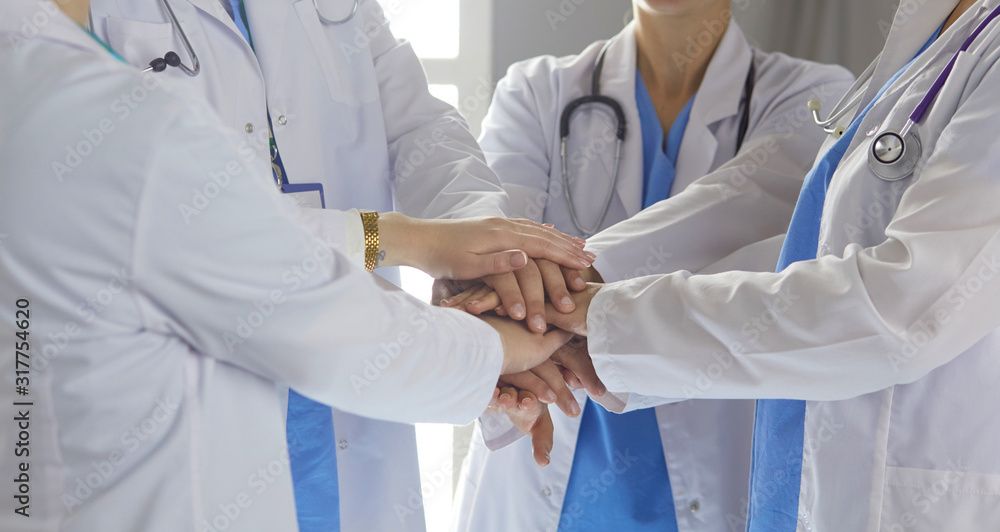 Team of medical workers holding hands together indoors, above view. Unity concept Team of medical workers holding hands together indoors, above view. Unity concept
