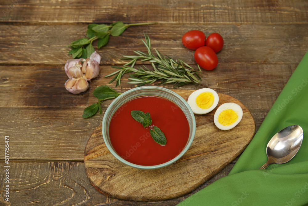 gazpacho spanish tomato soup topped with basil and tomatoes and garlic and egg on wooden rustic background. Top view. Copy space. Concept of national cuisine gazpacho spanish tomato soup topped with basil and tomatoes and garlic and egg on wooden rustic background. Top view. Copy space. Concept of national cuisine