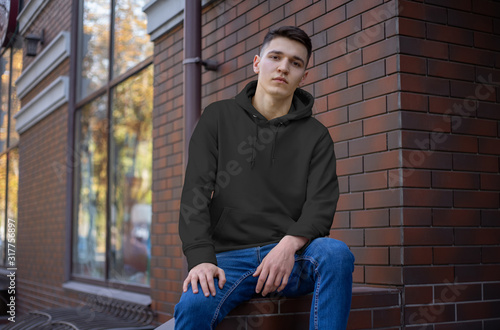 Mockup of an empty hoodie on a young guy in blue jeans, front view.
