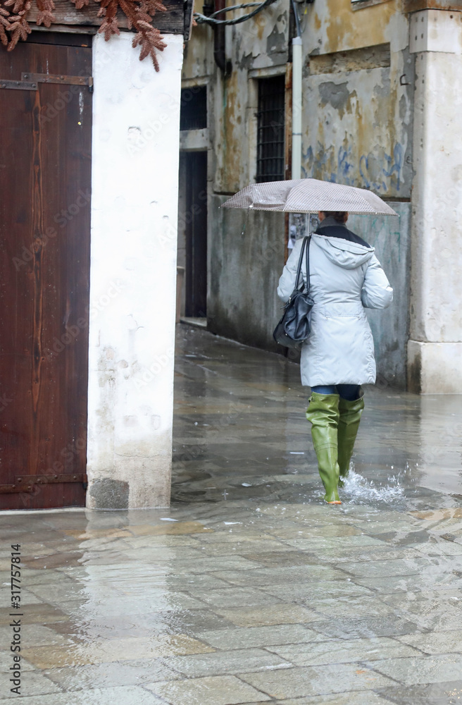 woman with umbrella while raining in Venice