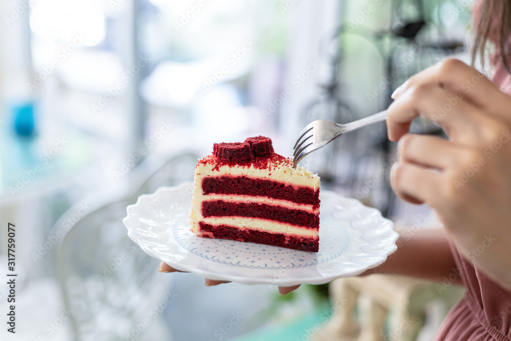 Hand hold fork for eating Red Velvet strawberry cheese cake. Hand hold fork for eating Red Velvet strawberry cheese cake.