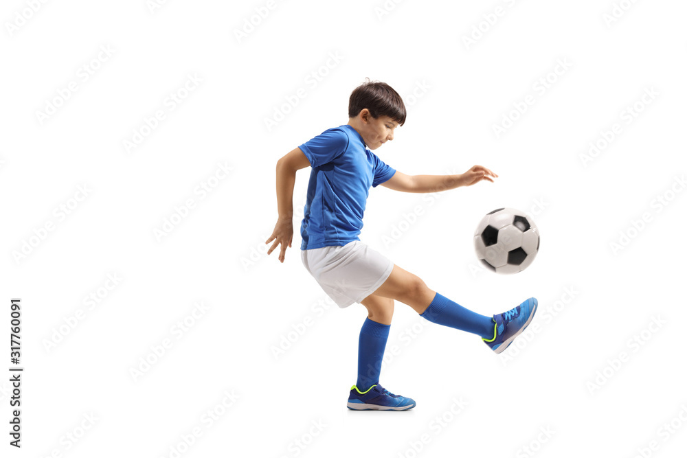 Boy football player juggling with a soccer ball