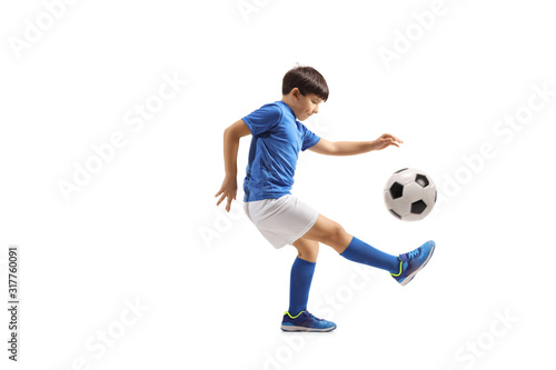 Fototapeta Naklejka Na Ścianę i Meble -  Boy football player juggling with a soccer ball