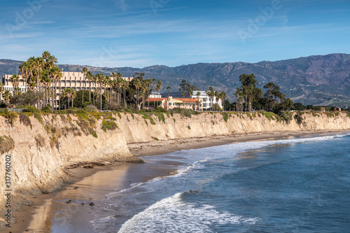 Goleta, CA, USA - January 2, 2020: UCSB, University California Santa Barbara. East side beige cliffs in front of several buildings. Blue ocean in front. Green foliage around. Hills on horizon and blue photo