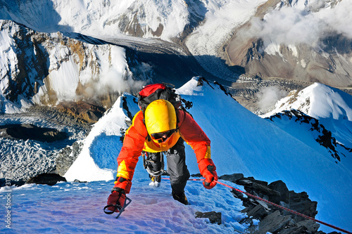 Climber ascending the summit of mountain peak. Climbing and mountaineering sport concept, Nepal Himalayas photo