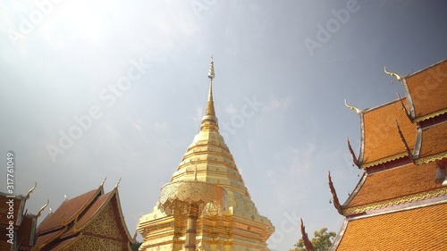 Temple in Thailand. The Buddha's Pagoda,The pagoda enshrines the Buddha's relics,Golden peak relics and blue sky with temple roof. photo