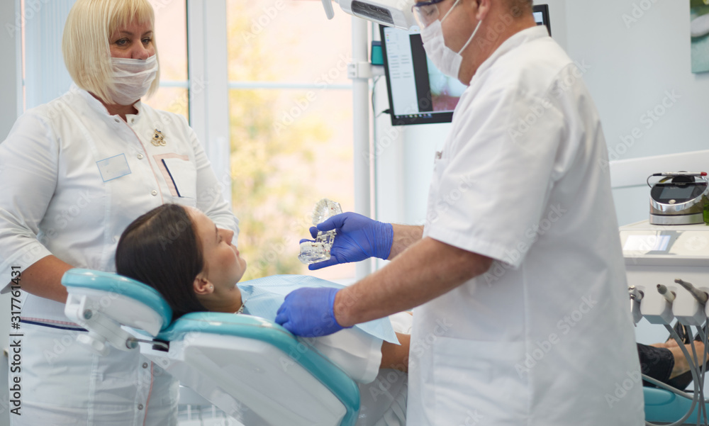 Doctor dentist treats teeth of a beautiful young girl patient. The girl on reception at the dentist. Doctor dentist treats tooth Doctor dentist treats teeth of a beautiful young girl patient. The girl on reception at the dentist. Doctor dentist treats tooth