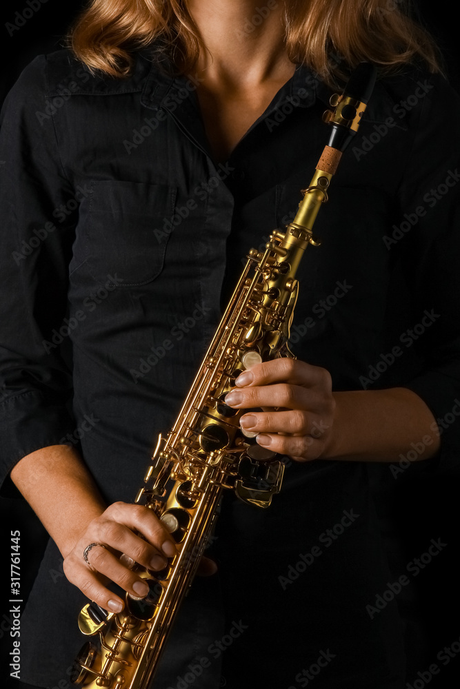 Obraz premium soprano saxophone in hands on a black background