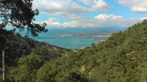 Mountain wiew with turquoise water and green trees. Reflection in the water. Beautiful spring landscape with mountains, forest and lake. Aerial View. Drone shot over a beautiful mountain forest lake