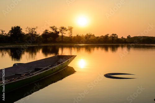 Close-up fishing boat parked at lake during sunset