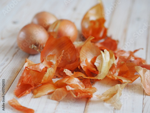 The use of onion skins in medicine and for coloring Easter eggs. Onion skin and onion on a wooden background. Onion is a storehouse of vitamin.