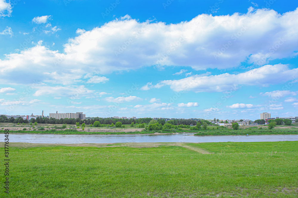 Obraz premium Beautiful summer landscape of empty grass field near river. Landscape on banks of Neris river in Kaunas city, Lithuania. .