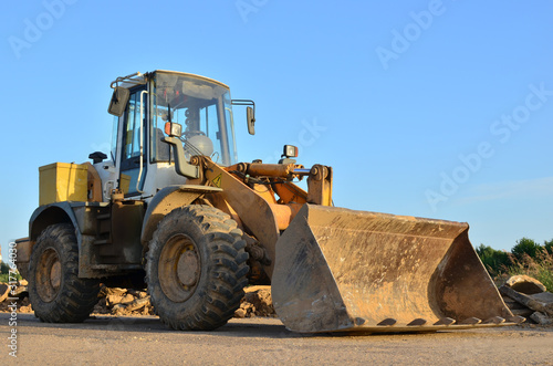 Front-end loader working on construction site during the renovation of the road.