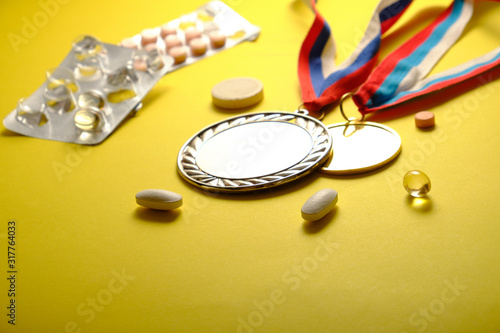 Medals on a yellow background, pills, doping symbol