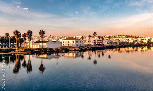 Panoramic view of the beach town of Conil de la Frontera, Spain, at dusk, and reflections on the calm waters of Salado river. photo