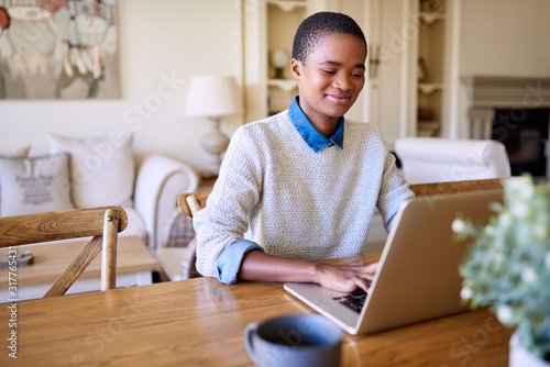 Smiling African American woman working online from home photo