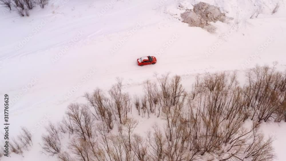 Orange Car rides on a winter snowy road, top view. Orange Car rides on a winter snowy road, top view.