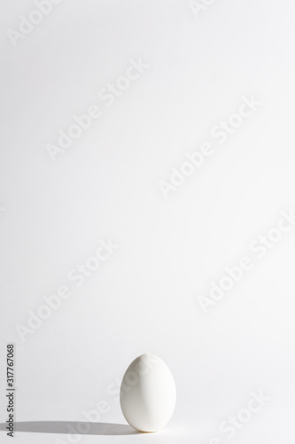 White egg on a white background in the center. Modern easter card. Design, visual art, minimalism
