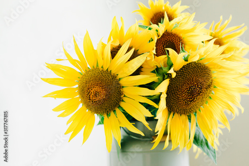 bouquet of bright yellow sunflower flowers in a retro vase on a white background