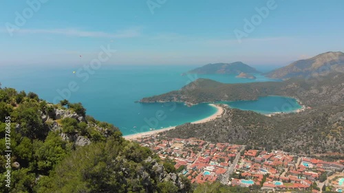Aerial view of summer city near mountains and sea water. Flying above mountains. Drone shot