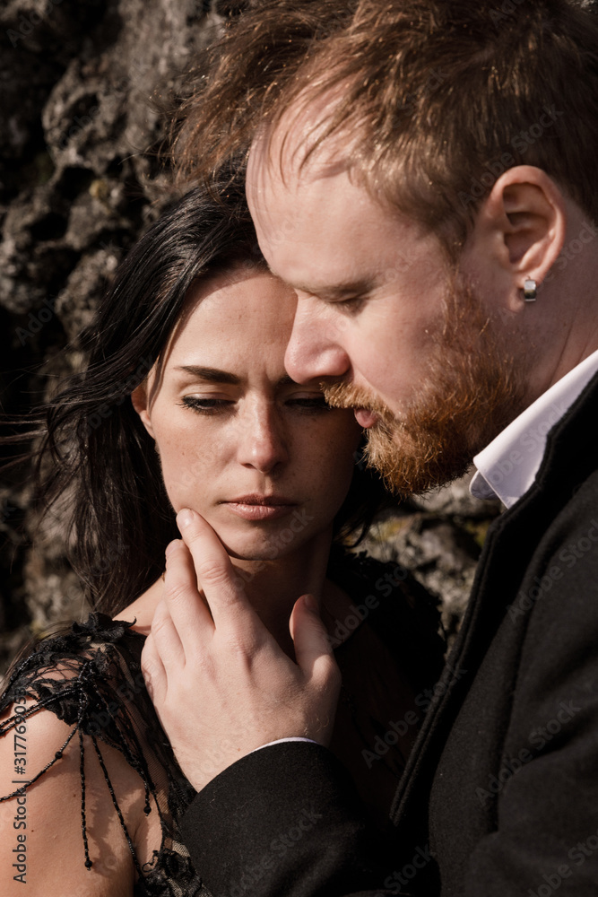 young wedding couple in black clothes stand on lava rock young wedding couple in black clothes stand on lava rock