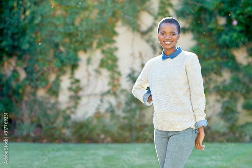 Smiling young African American woman standing outside in summer