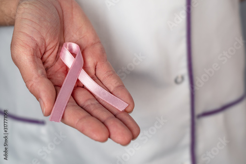 World cancer day. Cancer ribbon concept. Nurse holding ribbon symbol. Cancer awareness month. Breast cancer.