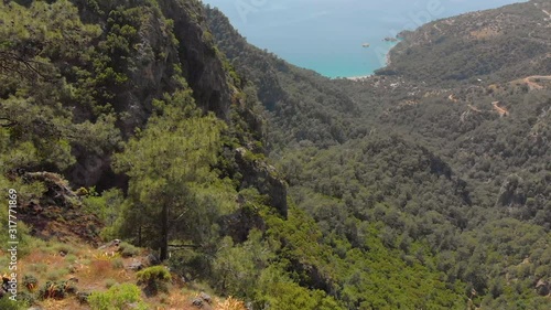 Aerial shot flying over couple standing on the edge of a cliff in the summer. Drone shot