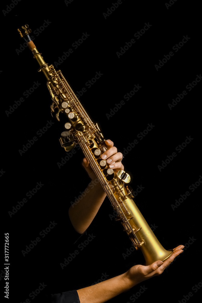 Fototapeta premium soprano saxophone in hands on a black background