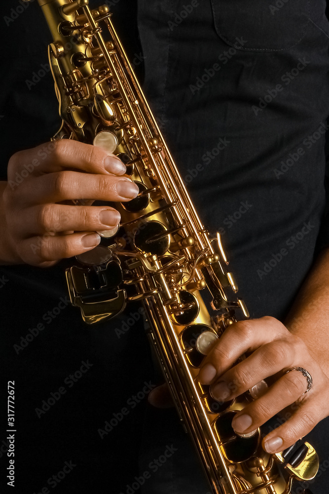 Obraz premium soprano saxophone in hands on a black background