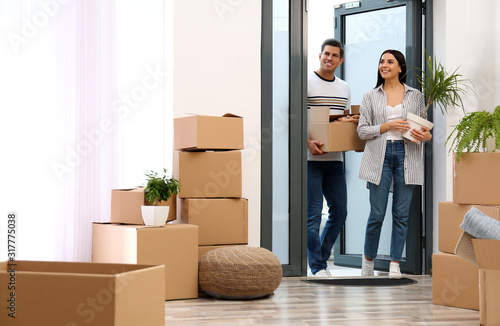 Φωτογραφία Happy couple entering their new flat with moving boxes