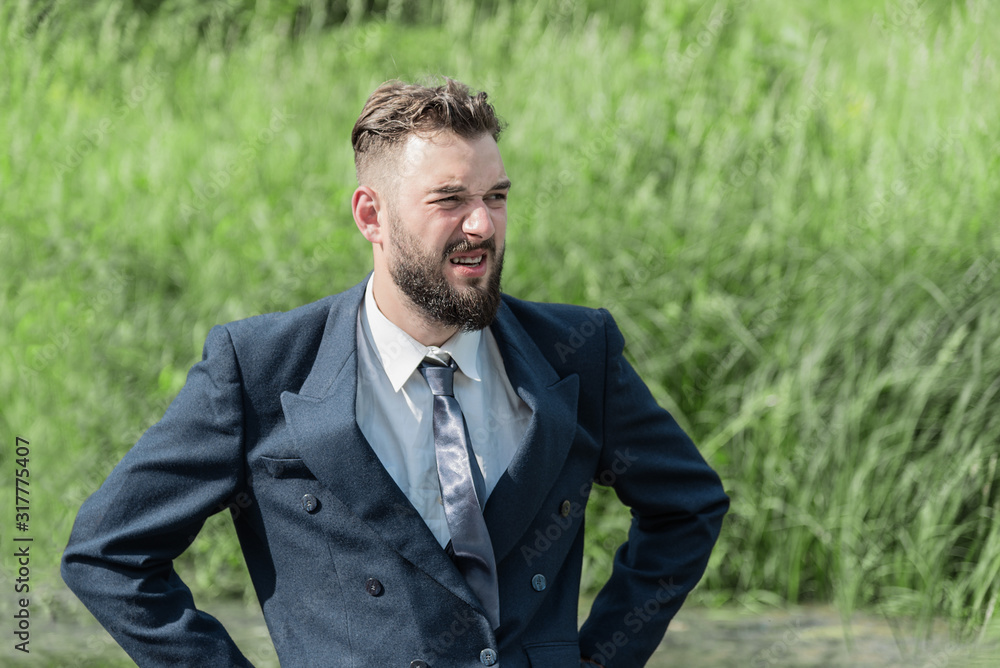 a man in a business suit in the swamp on a sunny day. office work concept