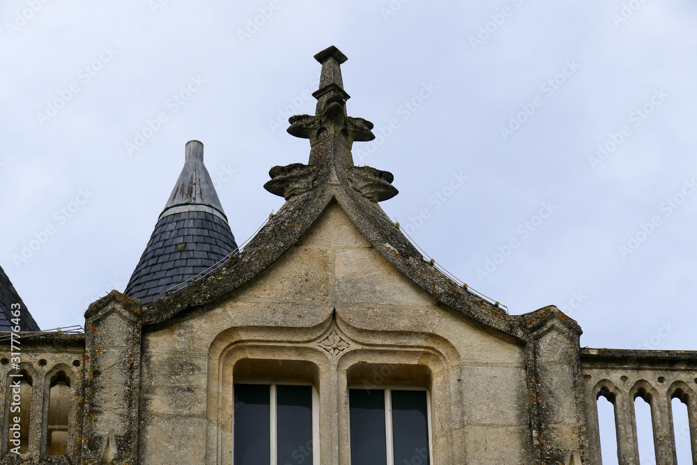 Closeup architectural details of ancient historic castle or chateau in France - against blue sky white clouds Closeup architectural details of ancient historic castle or chateau in France - against blue sky white clouds