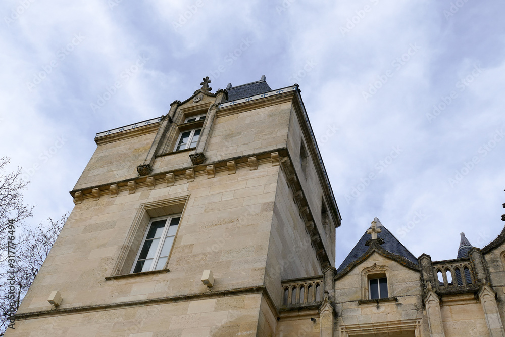 Closeup architectural details of ancient historic castle or chateau in France - against blue sky white clouds